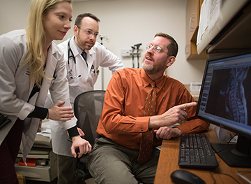 Spinal cord injury researcher reviews images on computer with students