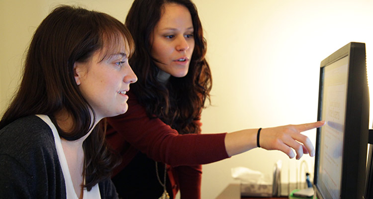 Two women review information on a computer